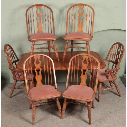 575 - A large mahogany dining table along with a set of six spindle back chairs.