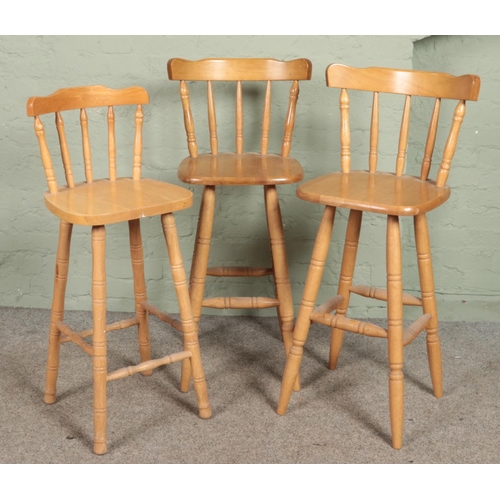 576 - Three beech stools with spindle backs and turned supports.