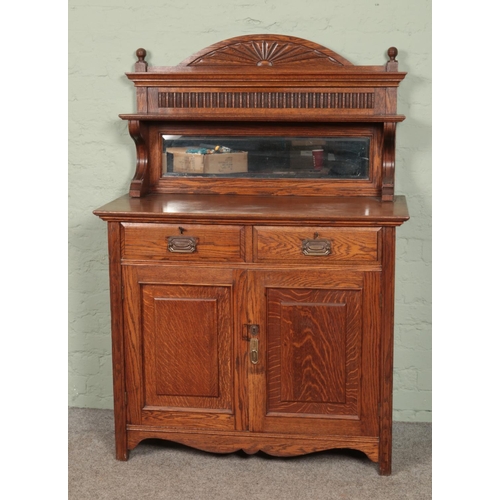 585 - A carved oak mirror back sideboard. Having drawer and cupboard base.