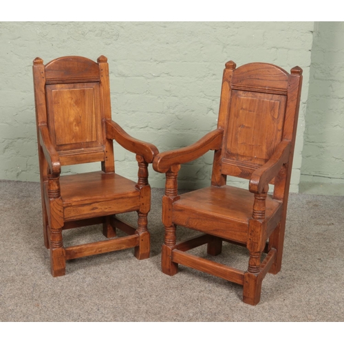 588 - A pair of childs elm arm chairs with panelled backs and turned supports. Height of back 73.5cm.