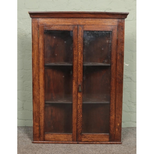 590 - An oak corner cupboard with glazed doors.