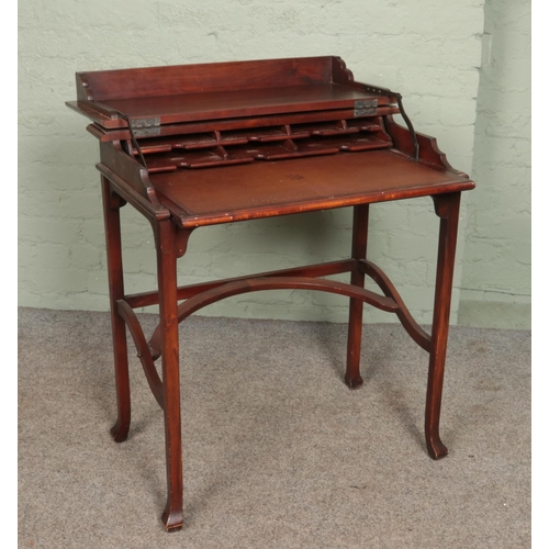 592 - A 20th century mahogany metamorphic table/desk. Height 81cm, Width 74cm, Depth 44cm.