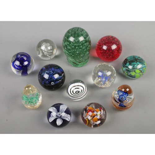 108 - Twelve assorted glass paperweights, to include Victorian dump and examples with bubble inclusions.