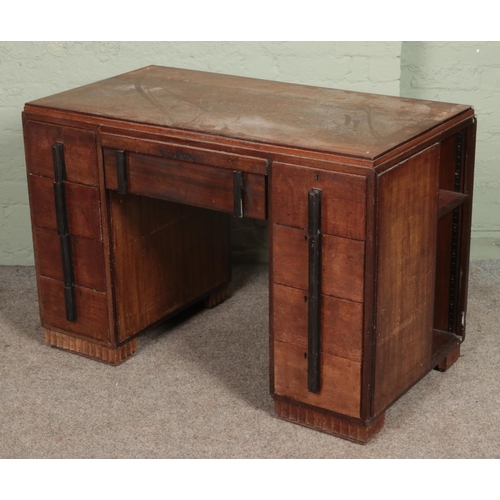 604 - An Art Deco mahogany desk with side storage shelves. (78cm x 114cm x 61cm)