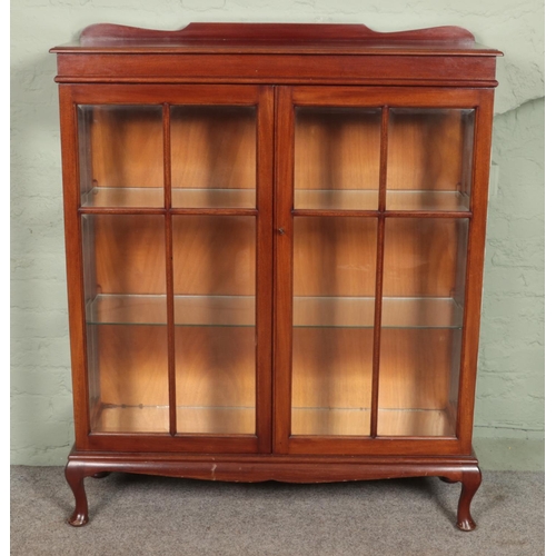 611 - A mahogany display cabinet with two glazed doors with bevelled edge glass and glass interior shelves... 