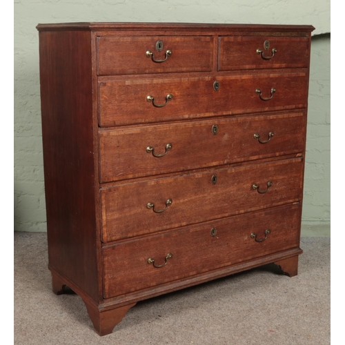 617 - A Georgian oak chest of drawers. Height 124cm, Width 115cm, Depth 53cm.