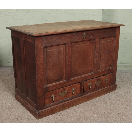 618 - A 19th century oak mule chest with triple panelled front and two drawers with tear drop handles and ... 