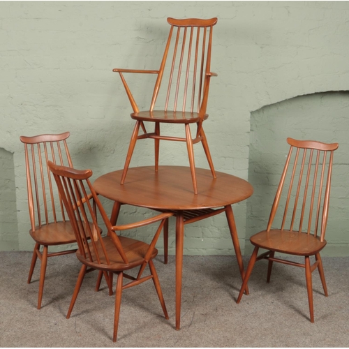 620 - An Ercol circular dining table and four goldsmiths chairs. Includes two carvers. (73cm x 90cm x 100c... 