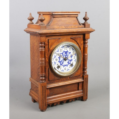 152 - A carved oak bracket clock with blue and white floral dial. Height 35cm.