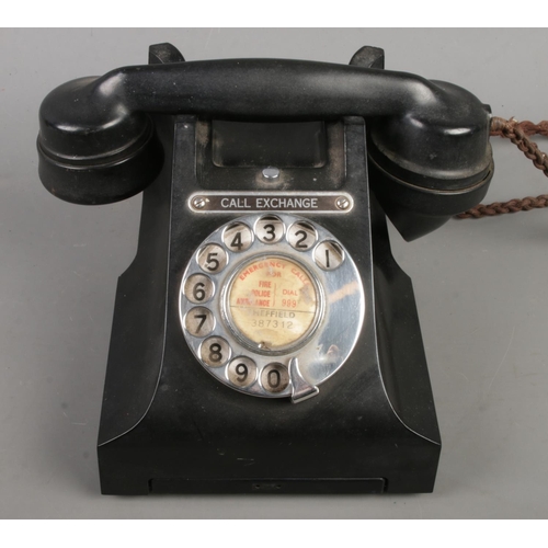 165 - A vintage black bakelite rotary telephone.
