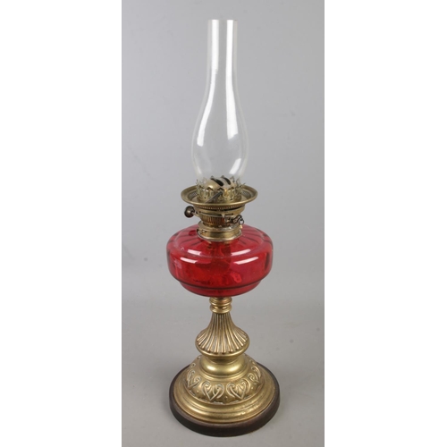 167 - A Victorian Young's cranberry glass and brass oil lamp. (63cm)
