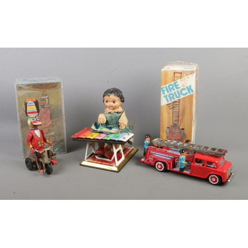 178 - Three vintage tinplate toys to include Xylophone player, 
boxed Friction Fire Truck and boxed Duck r... 