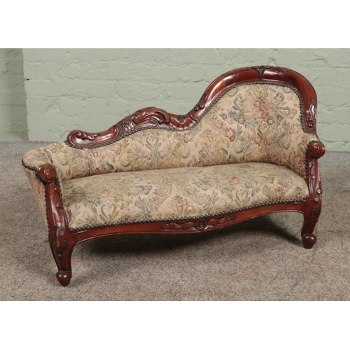 310 - A Victorian style carved mahogany child's chaise lounge. Height 48cm, Length 80cm.