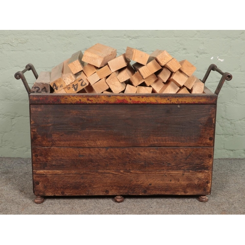 321 - A panelled log basket with metal surround, containing a large quantity of pre-cut logs. Bearing adde... 