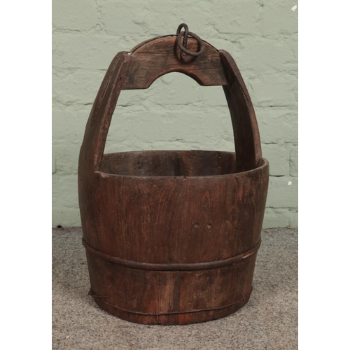 337 - An antique wooden slatted well bucket with metal mounts and loop. Height: 50cm.