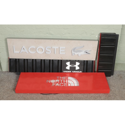 349 - Three shop lighting signs; North Face, Lacoste and Under Armour, with one other.