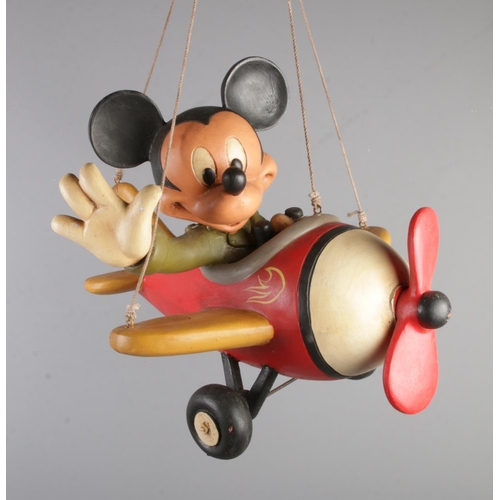 372 - A large hand painted poly resin Mickey Mouse figure flying a plane stamped Disney to wing.

Approxim... 