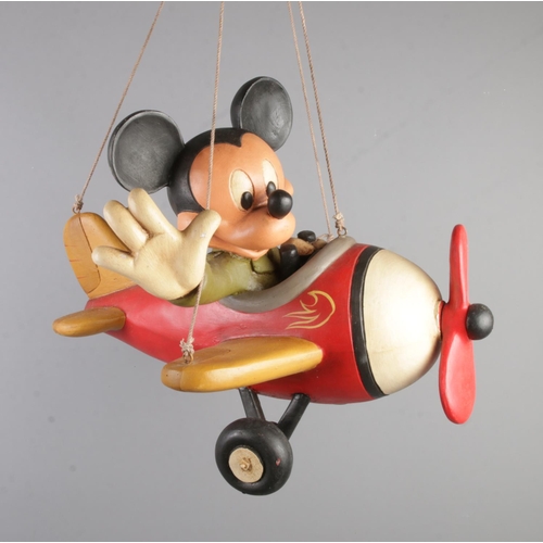 372 - A large hand painted poly resin Mickey Mouse figure flying a plane stamped Disney to wing.

Approxim... 