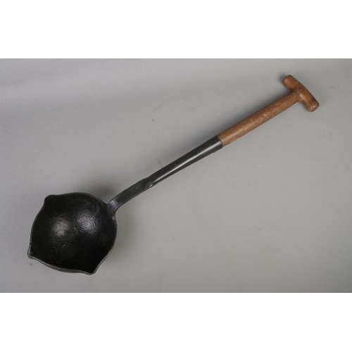 380 - A vintage smelting ladle with cast iron bowl and wooden handle. Stamped WD on wooden section and sta... 