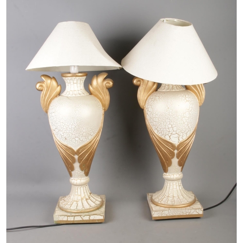 381 - A pair of gilt decorated table lamps formed as twin handled urns with shades.