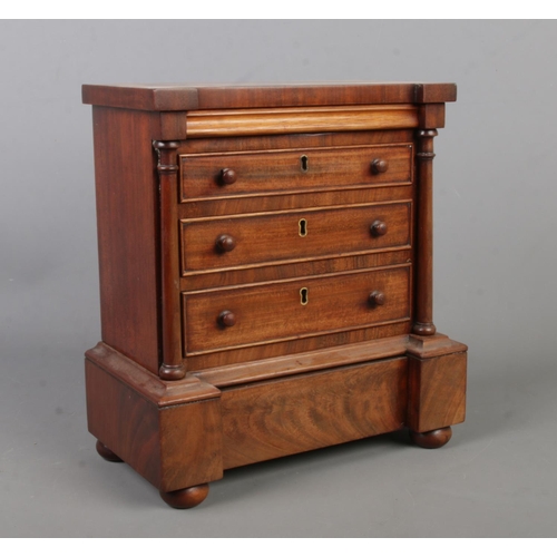 383 - A miniature mahogany chest of drawers in the Victorian style. 27cm x 25cm x 14cm.