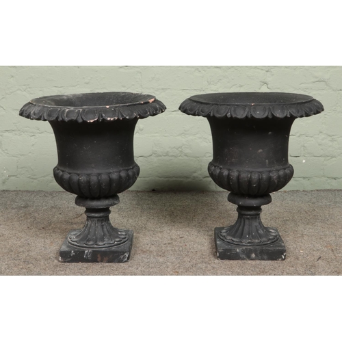 388 - A pair of black painted terracotta garden urns, 46cm high.