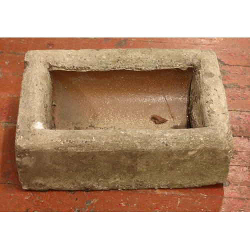 405 - A concrete garden trough, with slanted and raised back. Height: 22cm, Width: 59cm, Depth: 38cm.