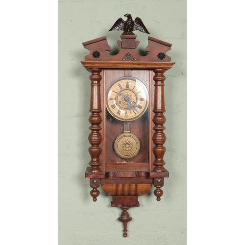 431 - A walnut and pine wall clock. Having eagle finial and chiming on a coiled gong.