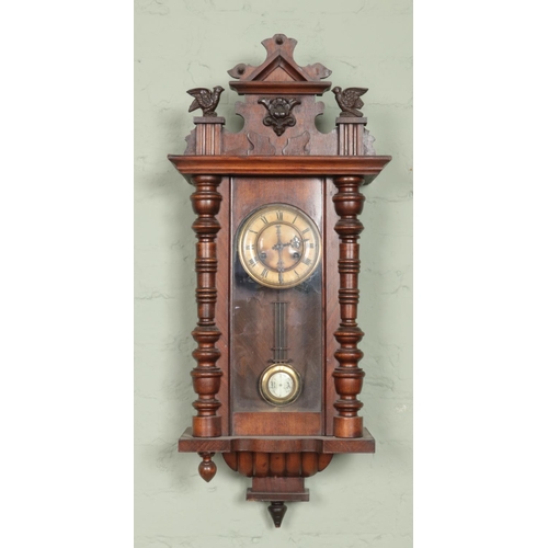 432 - A carved walnut wall clock with twin bird pediment. Chiming on a coiled gong.