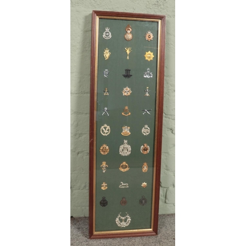 450 - A large framed display of 31 military cap badges. Includes Gordon Highlanders, Gurkhas, Royal Highla... 