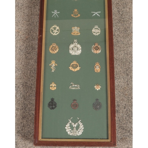 450 - A large framed display of 31 military cap badges. Includes Gordon Highlanders, Gurkhas, Royal Highla... 