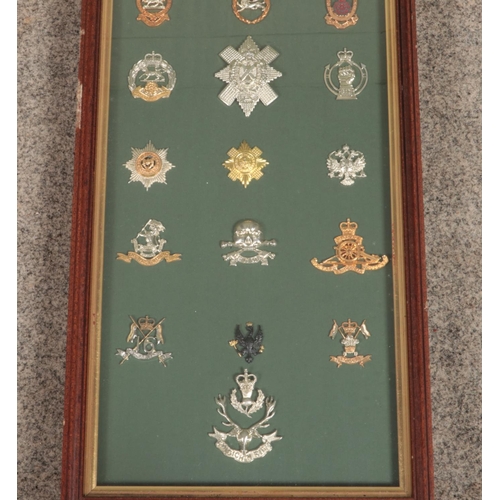 451 - A large framed display of 31 military cap badges. Includes Queen's Own Highlanders, Royal Regiment o... 