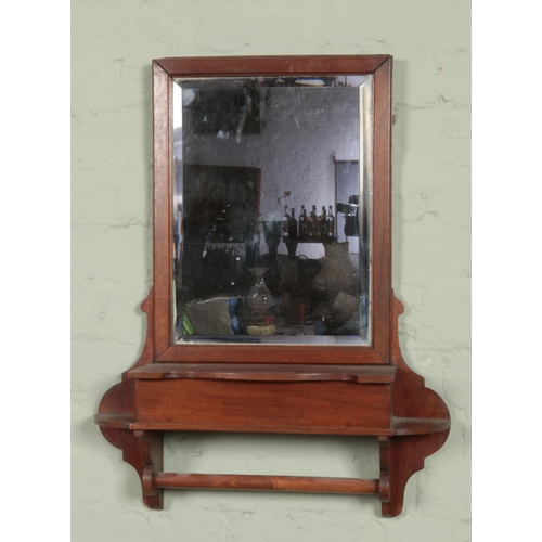 452 - A mahogany hall mirror. Having bevel edge glass, glove compartment and rail to underside.