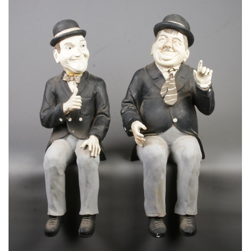 77 - A pair of composite Laurel and Hardy seated figures, both signed Mook. Height 60cm.