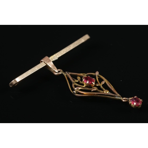 469 - A 9ct gold bar brooch with attached yellow metal pendant set with two pink stones. 4.2g.