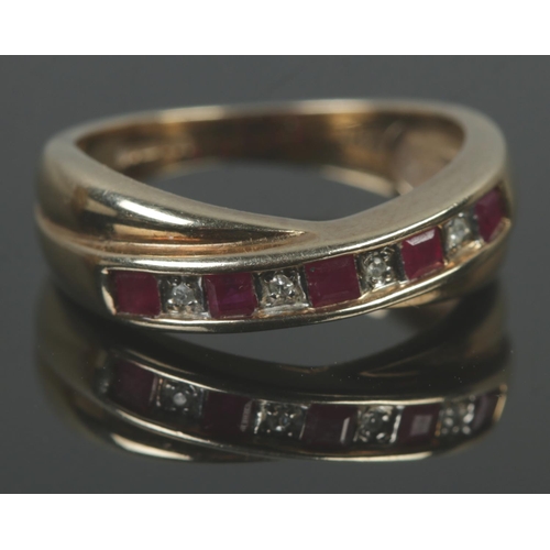 502 - A 9ct gold ruby and diamond crossover ring. Size M, 2.93g.