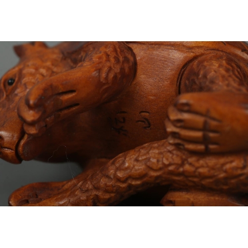 520 - A hand carved hardwood netsuke of a pangolin, signed to base.