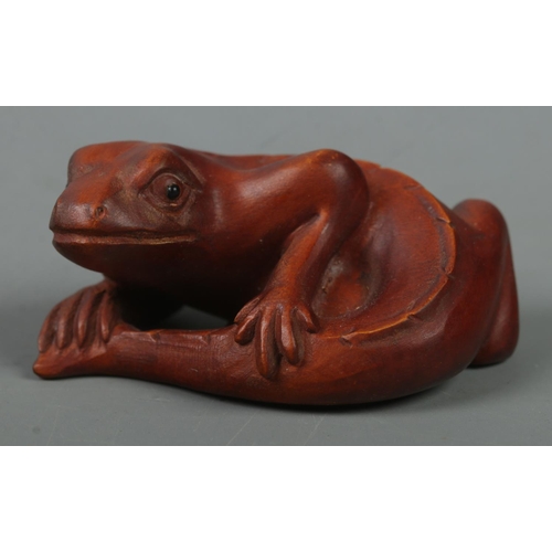 523 - A hand carved hardwood netsuke of a lizard, signed to base.