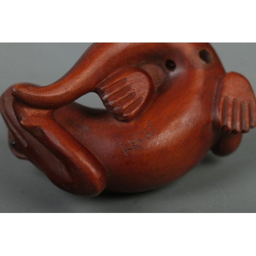 523 - A hand carved hardwood netsuke of a lizard, signed to base.