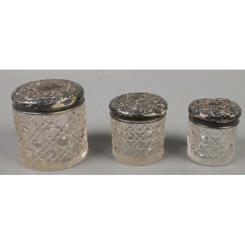 526 - Three silver topped cut glass graduated jars.