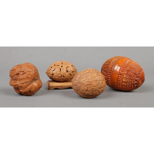 532 - A collection of decorative oriental carved nuts to include coquilla nut example.