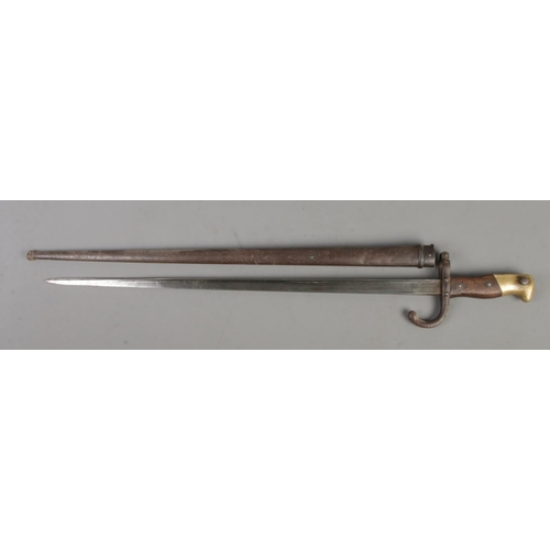 556 - A French 1874 bayonet with scabbard. Inscribed to edge of blade and dated 1878. Blade length 52cm. C... 