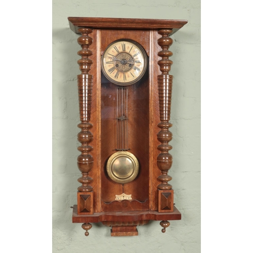 435 - A walnut Vienna wall clock. Having Roman numeral markers and chiming on a coiled gong.