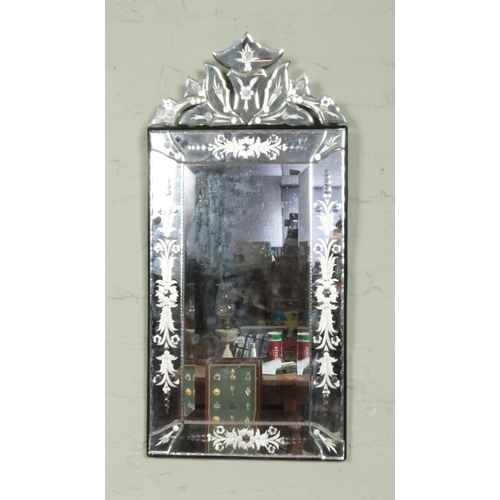 438 - A Venetian style etched glass mirror. 76cm x 36cm.