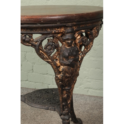 608 - A cast iron based pub table featuring Britannia and lion mask design with wooden circular top. Appro... 