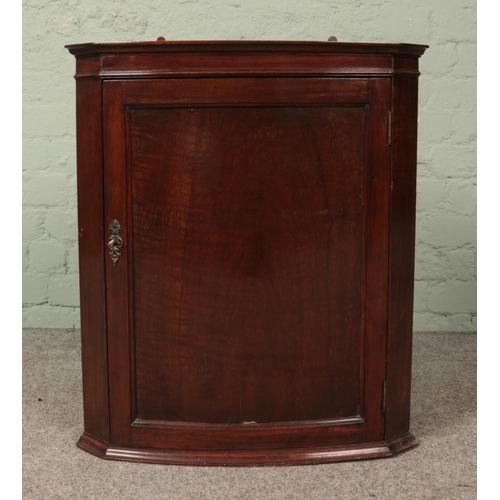 615 - A carved mahogany wall hanging corner cupboard.