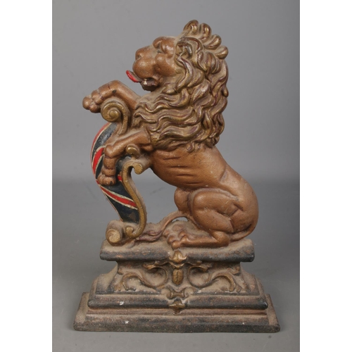 131 - A cast iron doorstop in the form of a lion rampant, raised on plinth base. Approx. 37cm tall.