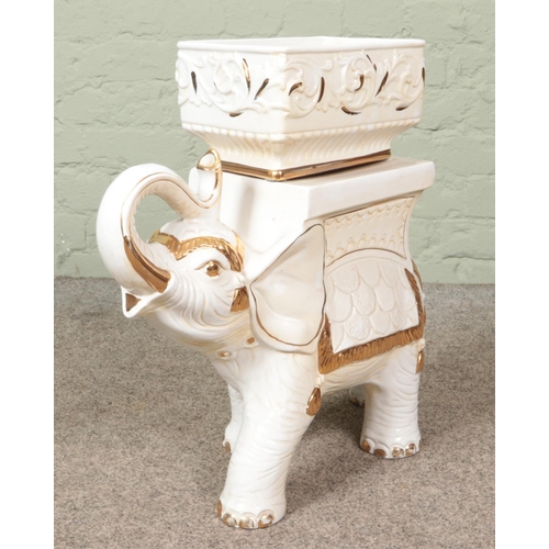 146 - A white and gilt pottery plant stand in the form of an elephant. Height 53cm.