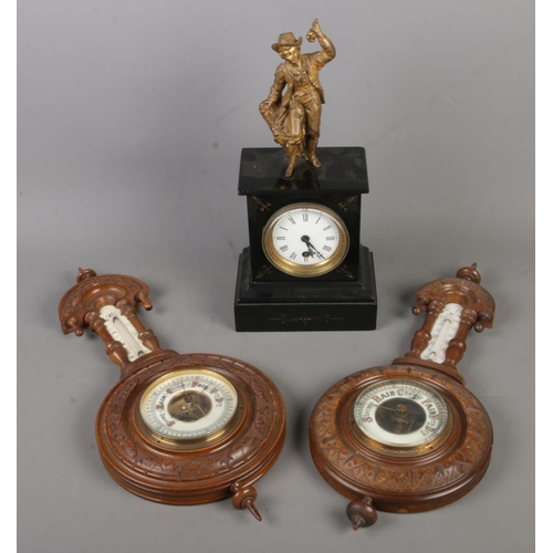 158 - A slate mantle clock decorated with gilt figure of a young boy along with two barometers.