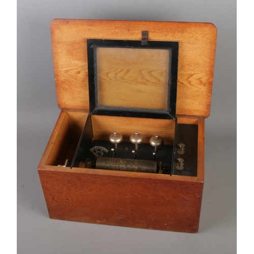 161 - An antique music box featuring three bells housed in oak case.